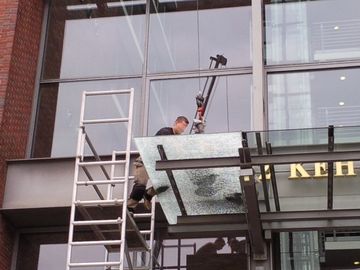 Glaser mit Leiter führt Glasreparatur in Hamburg aus